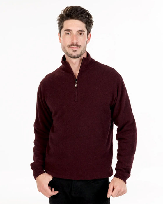 Man wearing a burgundy pullover with a quarter zip on a white background